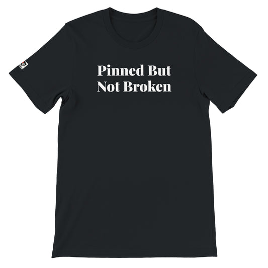 Black unisex t-shirt with the phrase ‘Pinned But Not Broken" printed on the front in white text